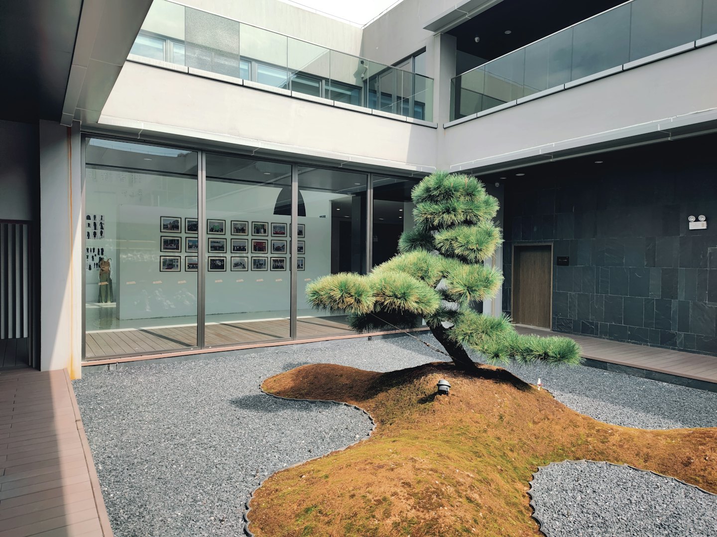 現代的な建物にアート作品が飾られ、日本庭園が見渡せる。